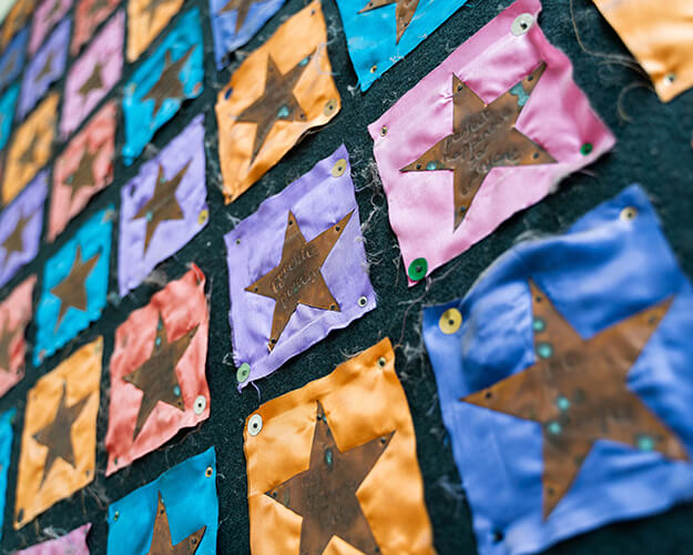 Clothe banner with multiple coloured squares with bronze stars