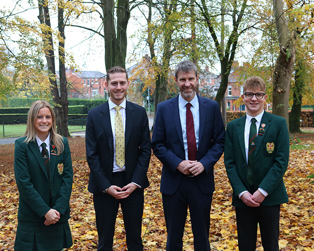 Teachers and students stood outside on leaves