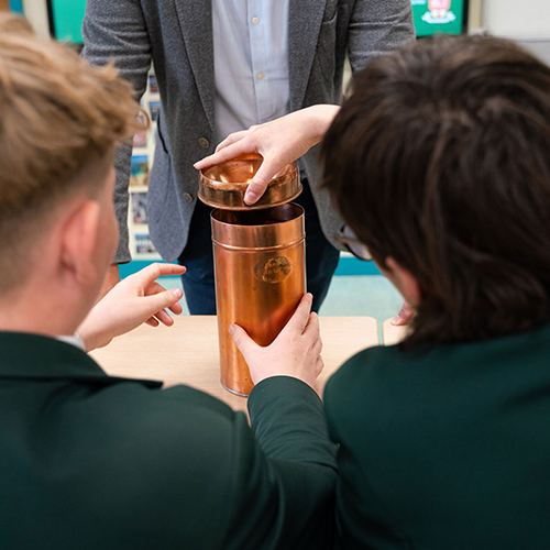 Two students opening a container